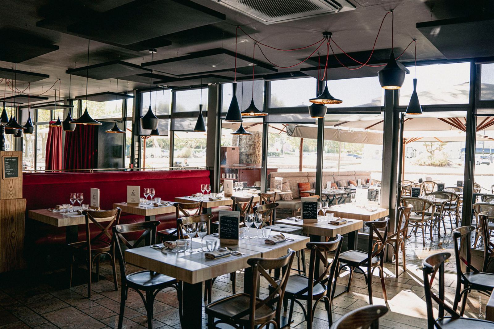 La salle bistrot, banquettes de velours rouge et baies vitrées